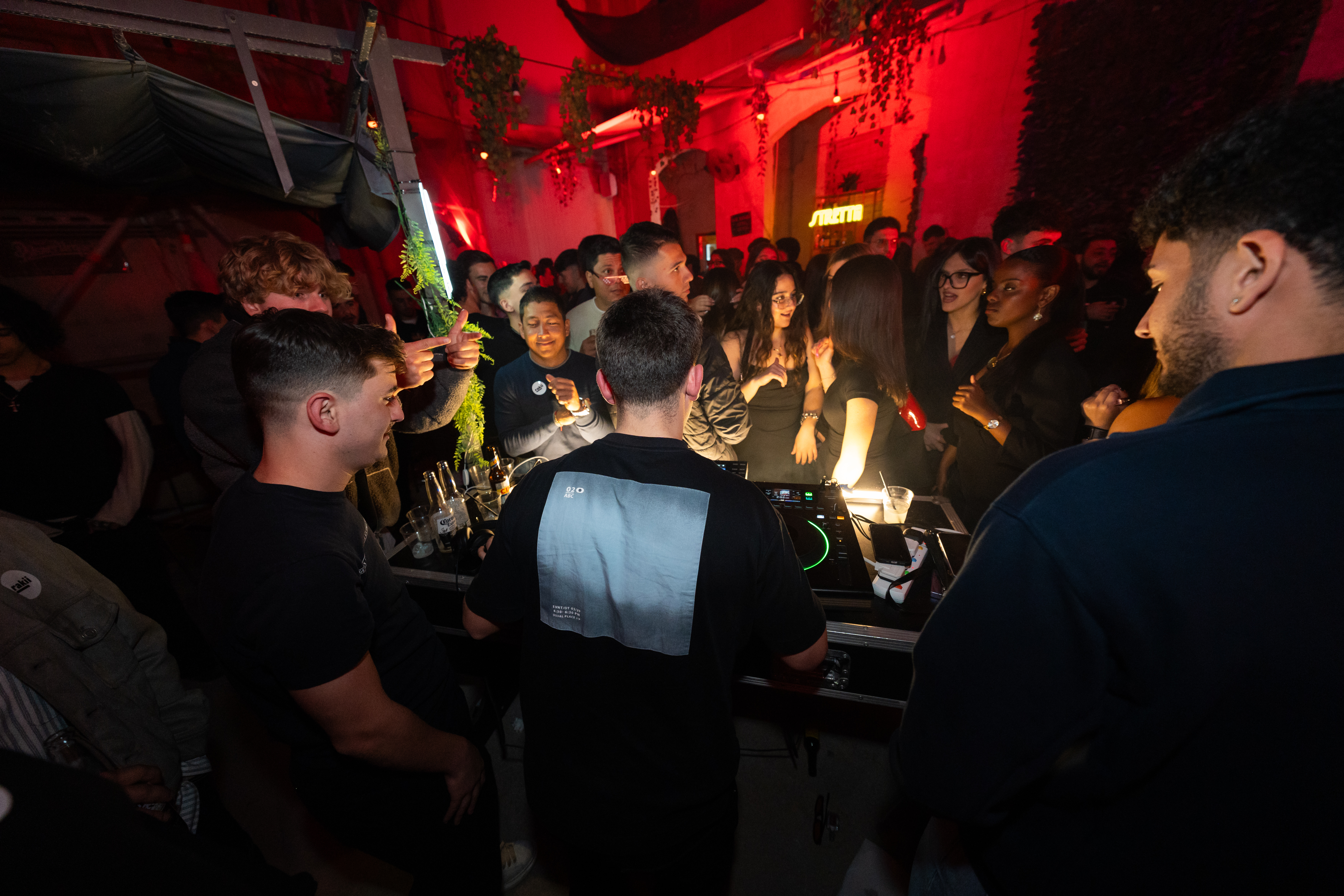 DJ booth with crowd under red light